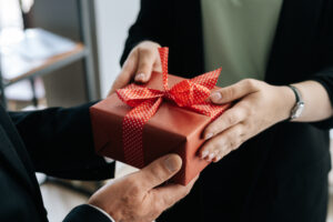 Une femme remet un cadeau rouge à un homme